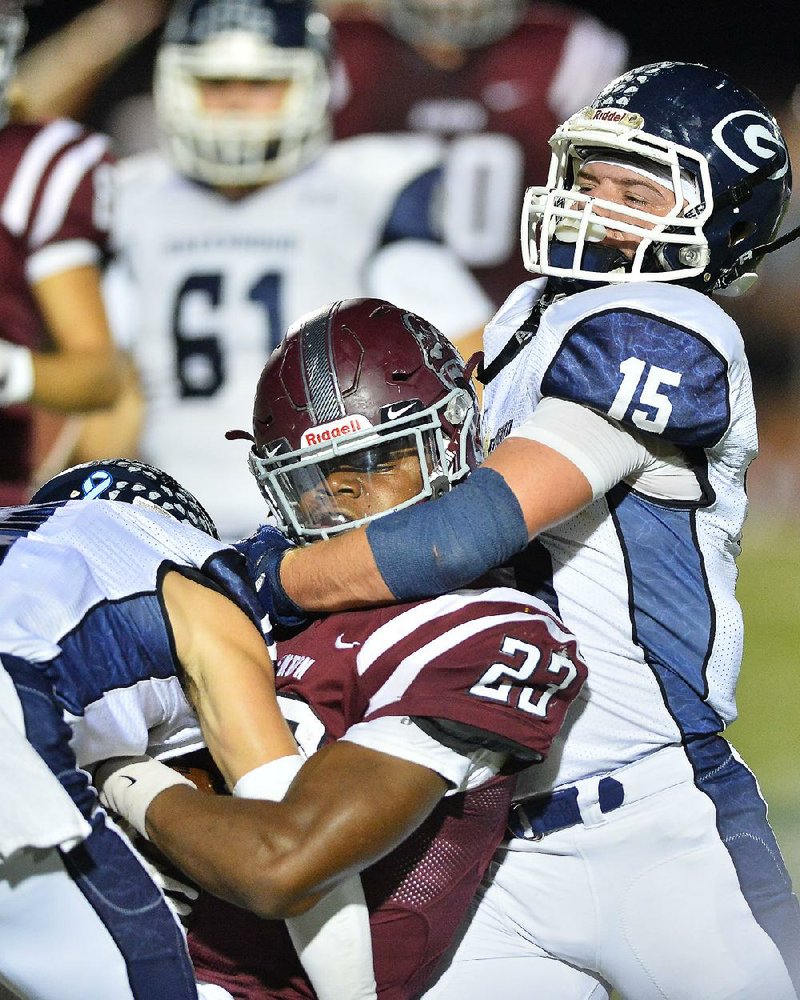 Greenwood linebacker Travis Cox (15) and a teammate tackle Benton running back Zak Wallace (23) during the Bulldogs’ 33-17 victory over the Panthers on Friday in Benton. For more high school football photos, visit arkansasonline.com/galleries.