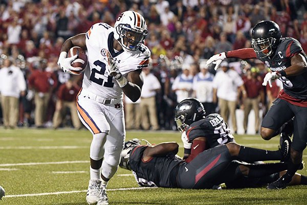 Auburn running back Kerryon Johnson, left, runs around the Arkansas defense to score a touchdown in the first half of an NCAA college football game in Fayetteville, Ark., Saturday, Oct. 21, 2017. (AP Photo/Michael Woods)

