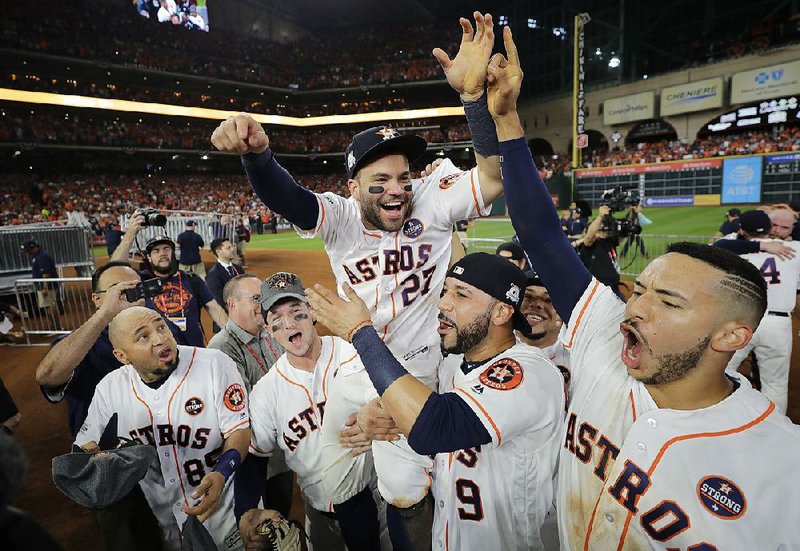 Houston Astros second baseman Jose Altuve is lifted by his teammates after the Astros defeated the New York Yankees 4-0 in Game 7 of the American League Championship Series on Saturday night.