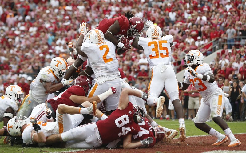 Alabama running back Bo Scarbrough leaps over Tennessee's defensive lineman Shy Tuttle, left, and linebacker Daniel Bituli, right, to score in the first half an NCAA college football game, Saturday, Oct. 21, 2017, in Tuscaloosa, Ala. (AP Photo/Brynn Anderson)