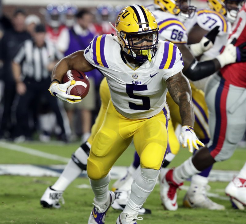 LSU running back Derrius Guice (5) runs for a first down past Mississippi defenders in the first half of an NCAA college football game in Oxford, Miss., Saturday, Oct. 21, 2017. (AP Photo/Rogelio V. Solis)