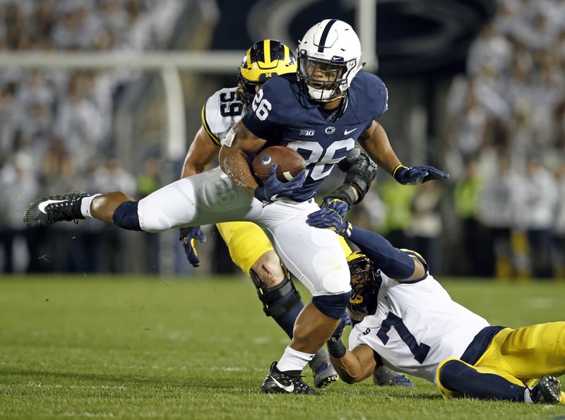 Penn State's Saquon Barkley (26) makes a move on Michigan's Khaleke Hudson (7) during the first half of an NCAA college football game in State College, Pa., Saturday, Oct. 21, 2017. (AP Photo/Chris Knight)