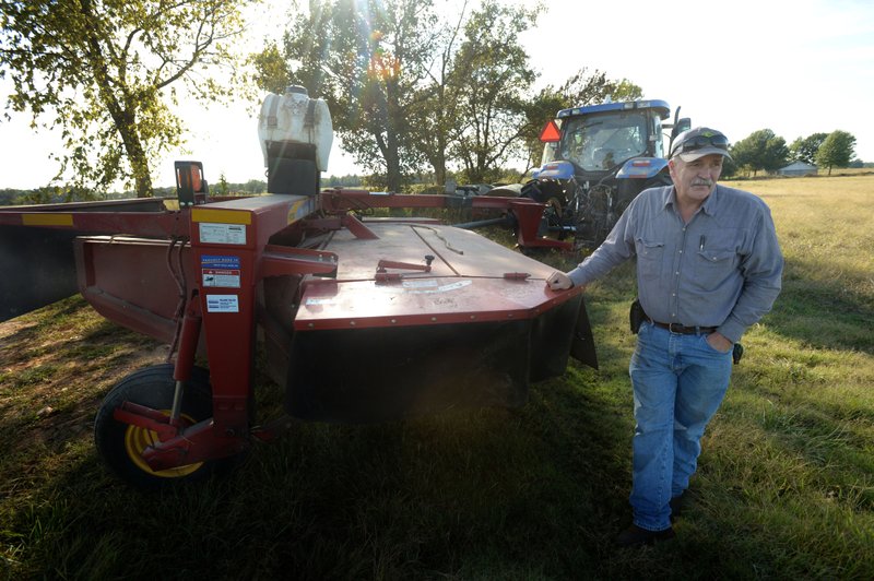 James Simpson of Bentonville speaks Wednesday as he prepares to cut grass in a field on his property on Scoggins Road in Cave Springs. Simpson is a fourth-generation farmer whose family owns property in Benton County, Cave Springs, Rogers and Bentonville and has land which is involved in an annexation debate.