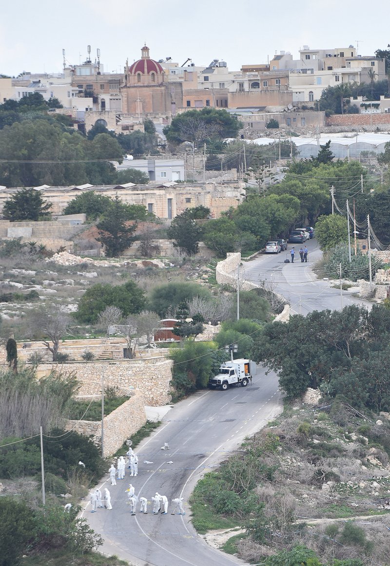 Forensic police work on the main road in Bidnija, Malta, which leads to Daphne Caruana Galizias house, looking for evidence on the blast that killed the journalist as she was leaving her home, Thursday, Oct. 19, 2017.