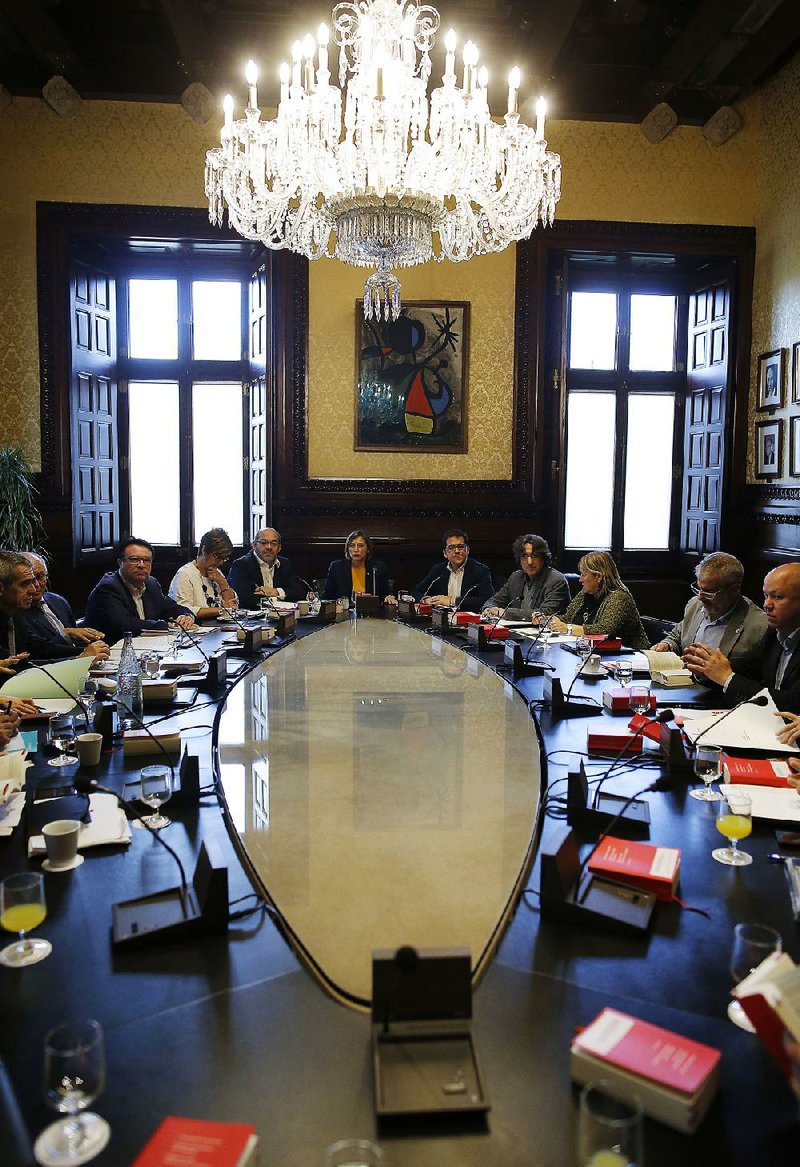 President of the Catalan parliament Carme Forcadell (center), meets Monday in Barcelona, Spain, with parliament representatives to discuss their next move after the Spanish government announced plans to remove members of the region’s pro-independence government.
