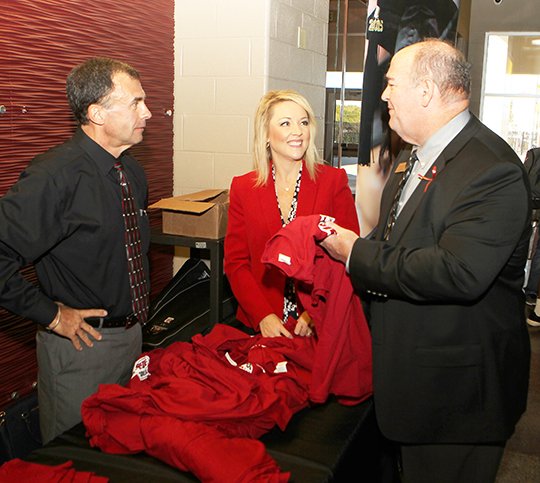 The Sentinel-Record/Richard Rasmussen REDDIES FOR WOLVES: Lake Hamilton Superintendent Steve Anderson, right, greeted Henderson State University Provost Steve Adkison, left, and Brandie Benton, associate provost for enrollment services and admissions, Monday morning in Lake Hamilton Wolf Arena for the announcement of the Wolf Reddie Scholarship. The award will be available to honor graduates from Lake Hamilton High School to fill any gaps left between their other financial aid and scholarships.