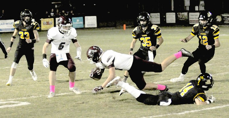 MARK HUMPHREY ENTERPRISE-LEADER Prairie Grove senior cornerback Tyler Davidson upends Gentry receiver Peyton Wright after a 1-yard gain on a pass play in the third quarter. The Tigers won 32-7 Friday to remain in the 4A-1 Conference race.