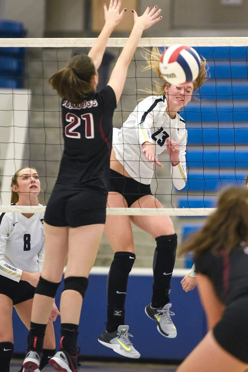 Bentonville High's Grayce Joyce (23) spikes the ball past Springdale High's Graycie Bohannan on Wednesday during the Class 7A state volleyball tournament in Conway.