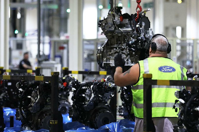 A Ford Transit van engine is taken from a conveyor at a Ford plant in Dagenham, England, earlier this month. Ford sales rose in Europe and South America as overall sales fell 2 percent in the third quarter. 