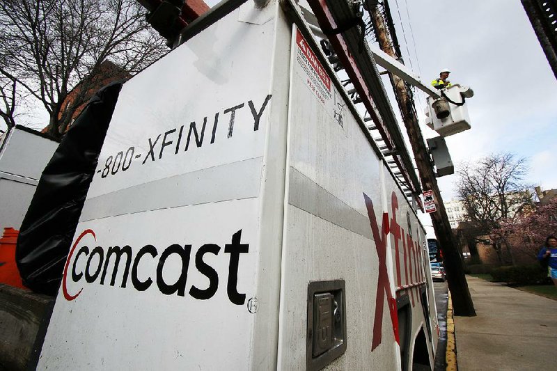 A Comcast lineman works in Pittsburgh earlier this year. Comcast said Thursday that it lost 125,000 video subscribers in the third quarter. 