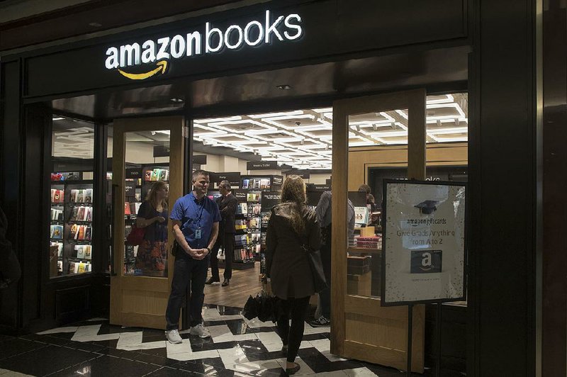 An Amazon Books employee greets a shopper at a store in the Time Warner Center in New York earlier this year. Amazon.com released its third-quarter report Thursday after the markets closed. 