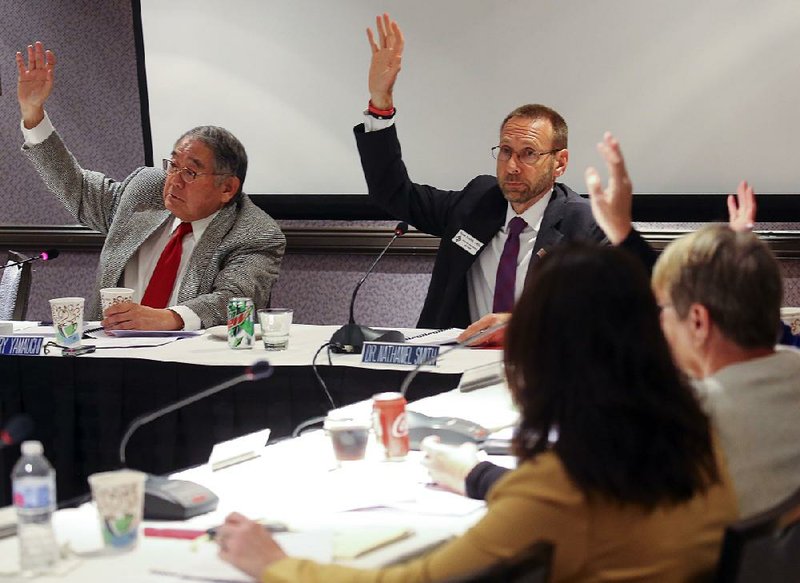 State Board of Health Chairman Dr. Terry Yamauchi (left) and Director Dr. Nate Smith (center) vote Thursday in Little Rock on the adoption of rules required by new state laws concerning abortion. 