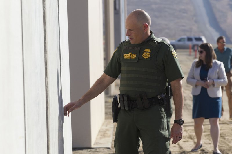 Ronald Vitiello, U.S. Customs and Border Protection's acting deputy commissioner, feels prototypes of a border wall on Thursday, Oct. 26, 2017, in San Diego. Contractors have completed eight prototypes of President Donald Trump's proposed border wall with Mexico, triggering a period of rigorous testing to determine if they can repel sledgehammers, torches, pickaxes and battery-operated tools. (John Gibbins/The San Diego Union-Tribune via AP, Pool)