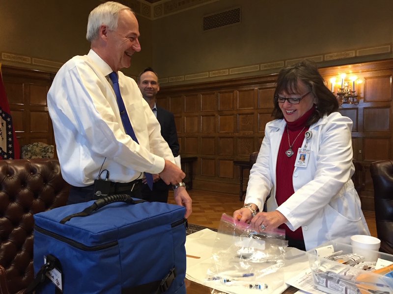 Dr. Neldia Dycus with the Arkansas Department of Health gives Gov. Asa Hutchinson an influenza vaccination Friday, Oct. 27, 2017, in the Governor's Conference Room.