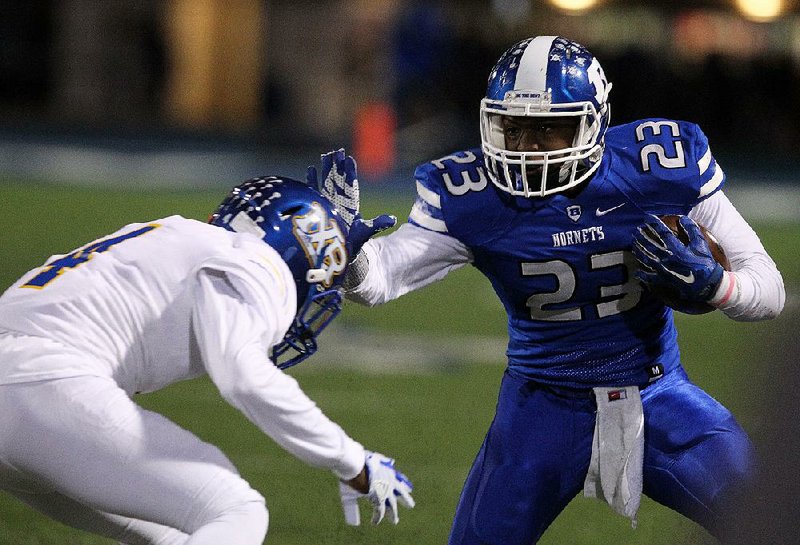 North Little Rock defensive back Jalen Grisley (left) fights through a stiff arm by Bryant running back Latavion Scott to make a tackle during the No. 2 Charging Wildcats’ 25-14 victory over the top-ranked Hornets on Friday in Bryant.