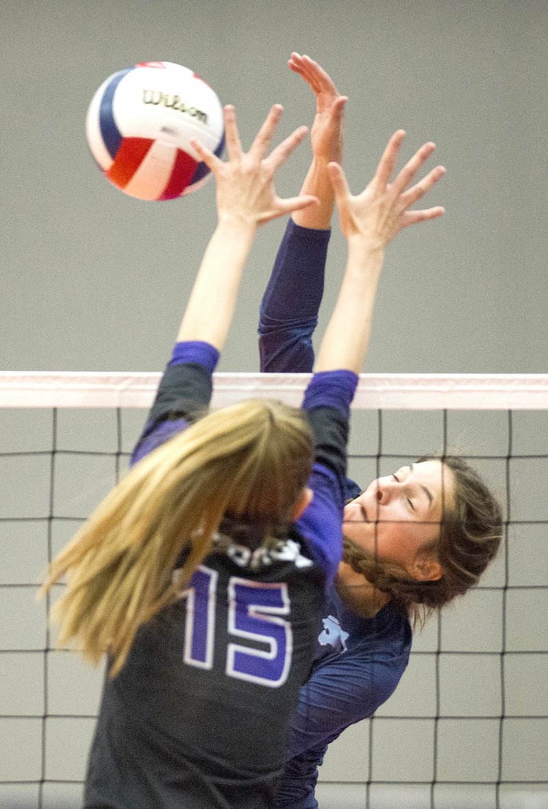 Springdale Har-Ber’s Lauren Thompson (back) spikes the ball past a Fayetteville defender Saturday during the Class 7A state championship match at Bank of Ozarks Arena in Hot Springs.