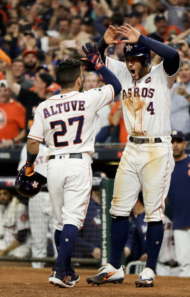 Jose Altuve (27) of the Houston Astros is congratulated by George Springer after his home run against the Los Angeles Dodgers in the fifth inning of Game 5 of the World Series onSunday night. Houston won 13-12 in the 10th inning.