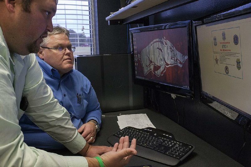 Detectives Olin Rankin (left) and Keith Eoff work out of their office in the cybercrime division Friday at the Benton County sheriff’s office in Bentonville. The office hopes mining for Bitcoins will help detectives catch criminals on the dark web.