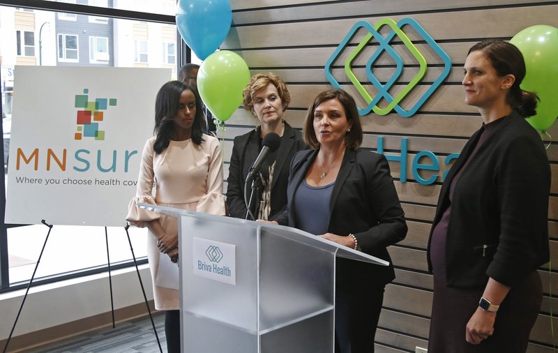 The Associated Press HEALTH CARE: Allison O'Toole, second from right, speaks to the media at the new offices of Briva Health, MNsure's largest enrollment partner, in Minneapolis. Health care consumers in most of the country are encountering a world of confusion and chaos as the open enrollment period to sign up for coverage approaches. The outlook is decidedly different in the 12 states that operate their own marketplaces. California, Colorado, Minnesota and other states that operate autonomous exchanges are pulling out all the stops to inform consumers. Also shown, from left, Hodan Guled, chief executive officer of Briva Health, Minneapolis Major Betsy Hodges and at right, Emily Piper, commissioner of Minnesota Human Services.
