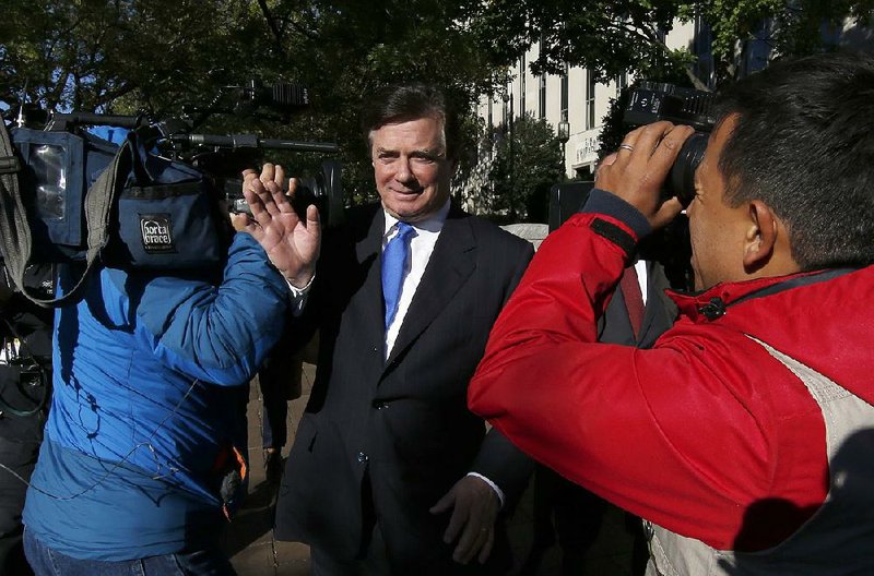 Paul Manafort makes his way through television cameras Monday as he walks from Federal District Court in Washington after pleading innocent to felony charges of conspiracy against the United States and other counts.