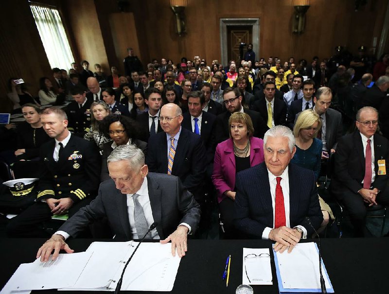 Defense Secretary James Mattis (front left) and Secretary of State Rex Tillerson prepare their documents during a Senate Foreign Relations Committee hearing on Capitol Hill dealing with the authorization of military force.