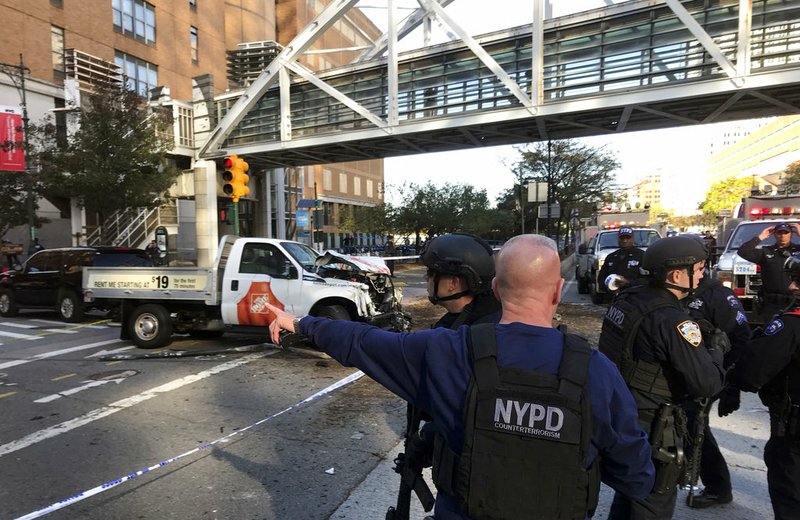 In this photo provided by the New York City Police Department, officers respond to a report of gunfire along West Street near the pedestrian bridge at Stuyvesant High School in lower Manhattan in New York on Tuesday, Oct. 31, 2017. 