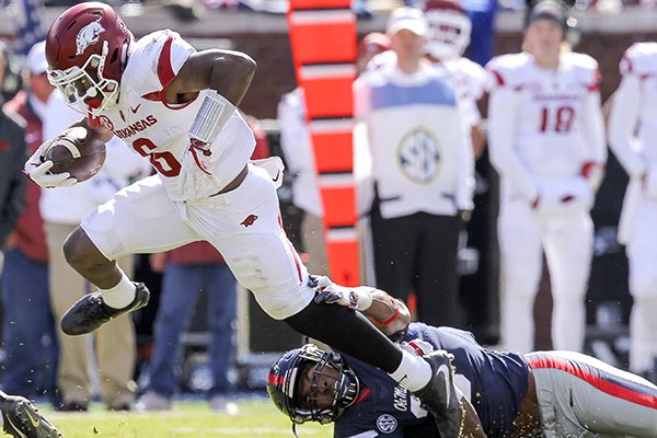 Arkansas running back T.J. Hammonds runs through a tackle attempt by Ole Miss linebacker DeMarquis Gates during the second quarter of a game Saturday, Oct. 28, 2017, in Oxford, Miss. 