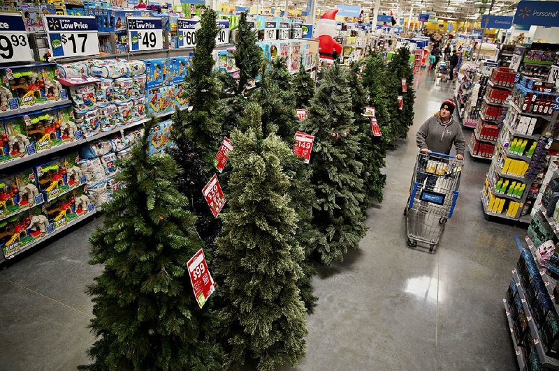Christmas trees are displayed at a Wal-Mart store in Chicago in this November 2015 file photo. The retailer said Tuesday that it will add more helpers to assist shoppers during the Christmas season.