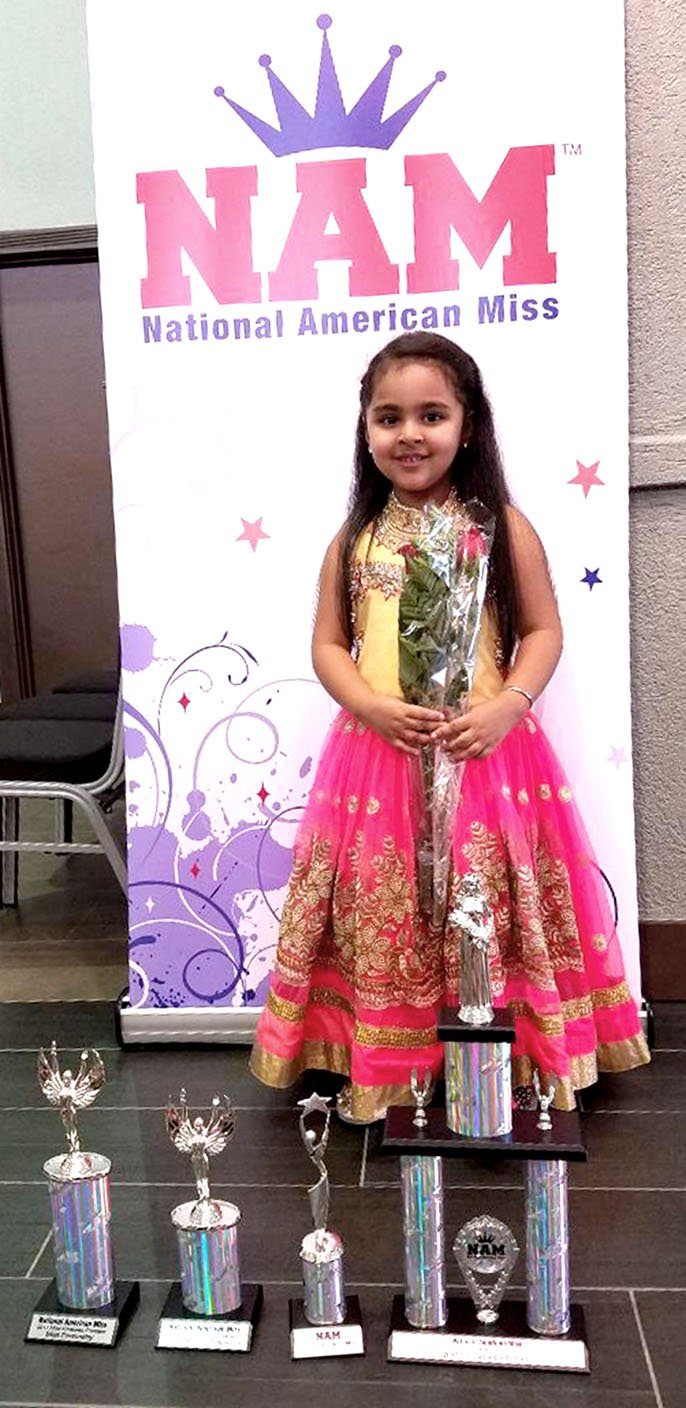 Photo by Mike Eckels Vidhi Sood, daughter of Vikas and Dimple Sood of Decatur, stands in front of her trophies she won during the National American Miss contest at the Four Points by Sheraton in Bentonville June 30.