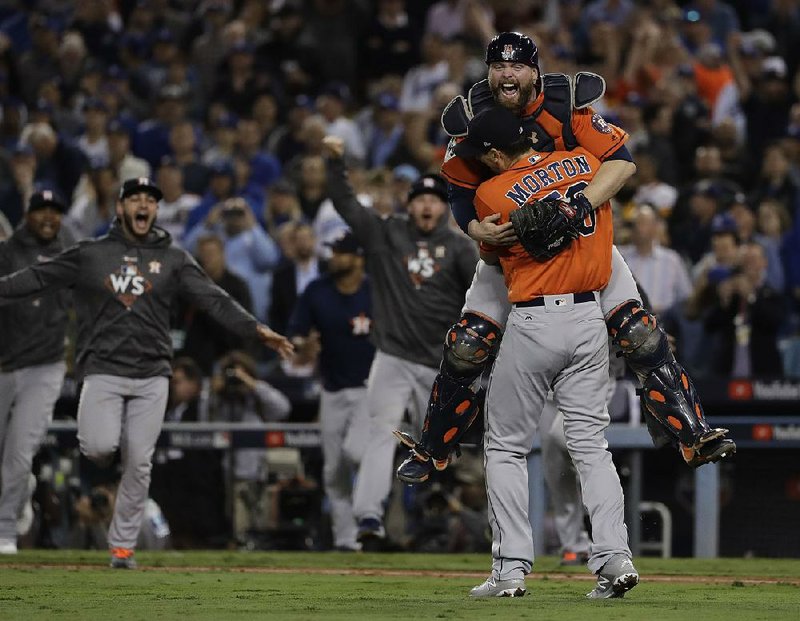 Houston Astros catcher Brian McCann leaps into the arms of pitcher Charlie Morton after the Astros defeated the Los Angeles Dodgers 5-1 in Game 7 of the World Series at Dodger Stadium in Los Angeles. It is the Astros’ first World Series title.