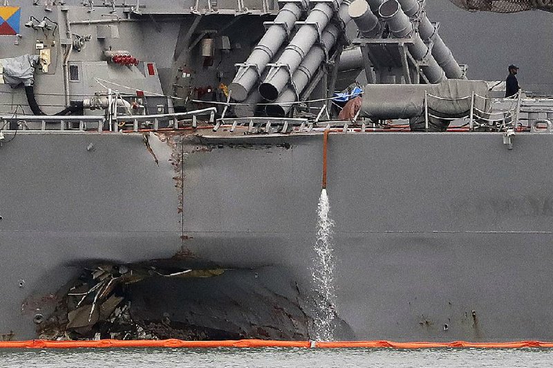 The damaged USS John S. McCain is shown at Singapore’s Changi naval base on Aug. 22, a day after it collided with an oil tanker and 10 sailors died. 