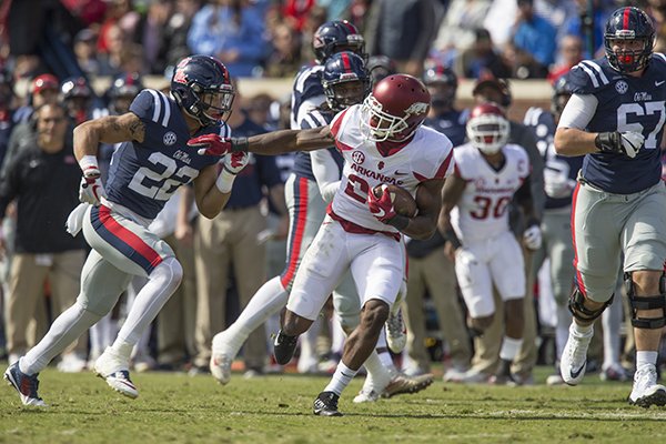 Arkansas safety Josh Liddell returns an interception as Ole Miss running back Jordan Wilkins (22) chases him during a game Saturday, Oct. 28, 2017, in Oxford, Miss. 