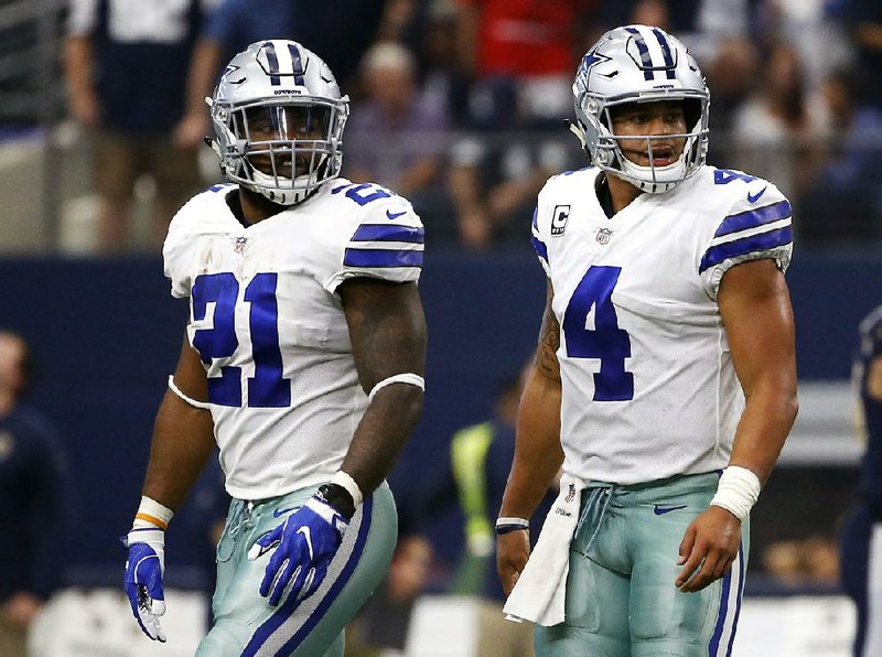 In this Oct. 1, 2017, file photo, Dallas Cowboys running back Ezekiel Elliott (21) and quarterback Dak Prescott (4) walk off the field after an unsuccessful two-point conversion in the second half of an NFL football game against the Los Angeles Rams in Arlington, Texas. 