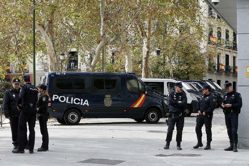 Police officers stand outside the National Court, at right, in Madrid on Thursday.