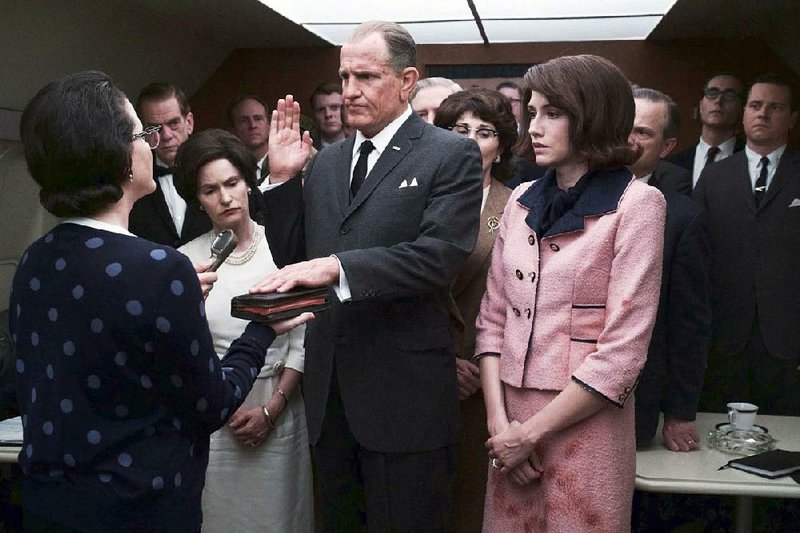 Flanked by his wife, Lady Bird (Jennifer Jason Leigh), and Jackie Kennedy (Kim Allen), Lyndon Baines Johnson (Woody Harrelson) is sworn in as president of the United States in Rob Reiner’s LBJ.