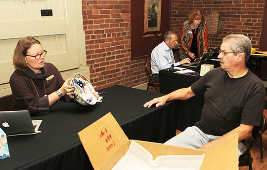 The Sentinel Record/ Richard Rasmussen PROFESSIONAL OPINION: Moran Antique & Fine Art Auctioneers appraiser Maranda Moran, left, of Pasadena, Calif., looks over an antique Japanese bowl for Hot Springs resident Mike Caviness during the inaugural "What's it Worth?" fundraiser on Thursday at Transportation Depot.