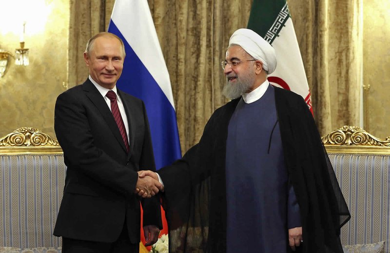 The Associated Press RUSSIAN RELATIONS: In this photo released by an official website of the office of the Iranian Presidency, Iran's President Hassan Rouhani, right, shakes hands with Russian President Vladimir Putin Wednesday at the Saadabad Palace in Tehran, Iran. After watching for years as the United States called the shots in the region, Russian President Vladimir Putin is seizing the reins of power in the Middle East, establishing footholds and striking alliances with unlikely partners. From Syria's battlefields to its burgeoning partnership with Iran and Turkey to its deepening ties with Saudi Arabia, Russia is stepping in to fill a void left by the United States.