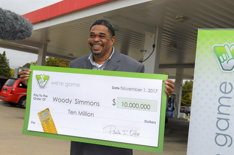 In this image provided by the Virginia State Lottery, Woody Simmons holds a ceremonial check for $10 million dollars in Woodbridge, Va., on Nov. 1, 2017. 