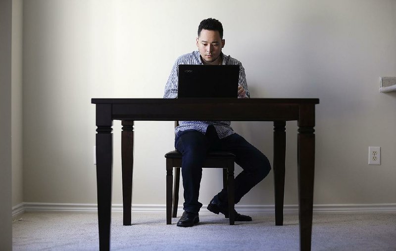 In this October photo, freelancer Jaimyn Chang works in the solitude of his home office in Raleigh, N.C. 