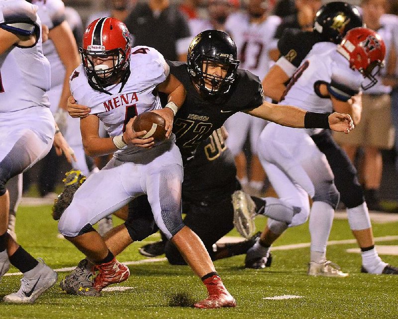 Joe T. Robinson defensive tackle Brayden Fitts (right) sacks Mena quarterback Zane Stephens on Friday at Charlie George Stadium in Little Rock.