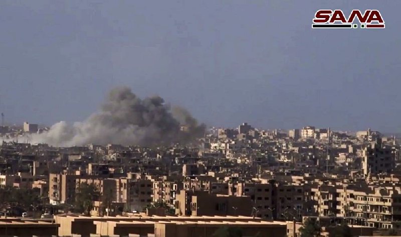 This frame grab from a video released on Thursday by the Syrian official news agency SANA shows smoke and debris rising after Syrian government shelling of the city of Deir el-Zour during a battle against Islamic State militants. 