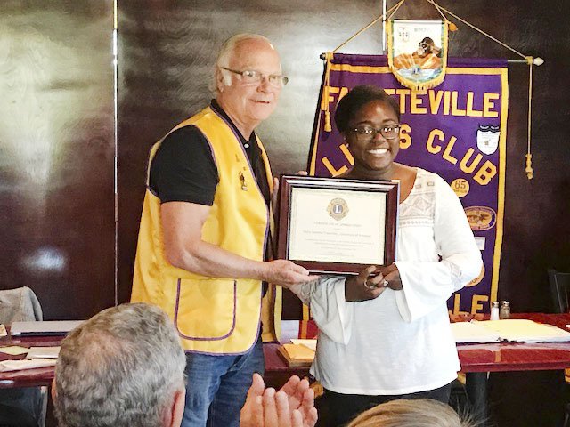 Lion President Steve Gray (from left) presented a plaque of appreciation to Allyson Braggs, Delta Gamma VP Foundation, in recognition of a $4,800 donation made from Delta Gamma to Fayetteville Lions Club from the Delta Gamma Anchor Splash fundraising event held at the University of Arkansas last spring.