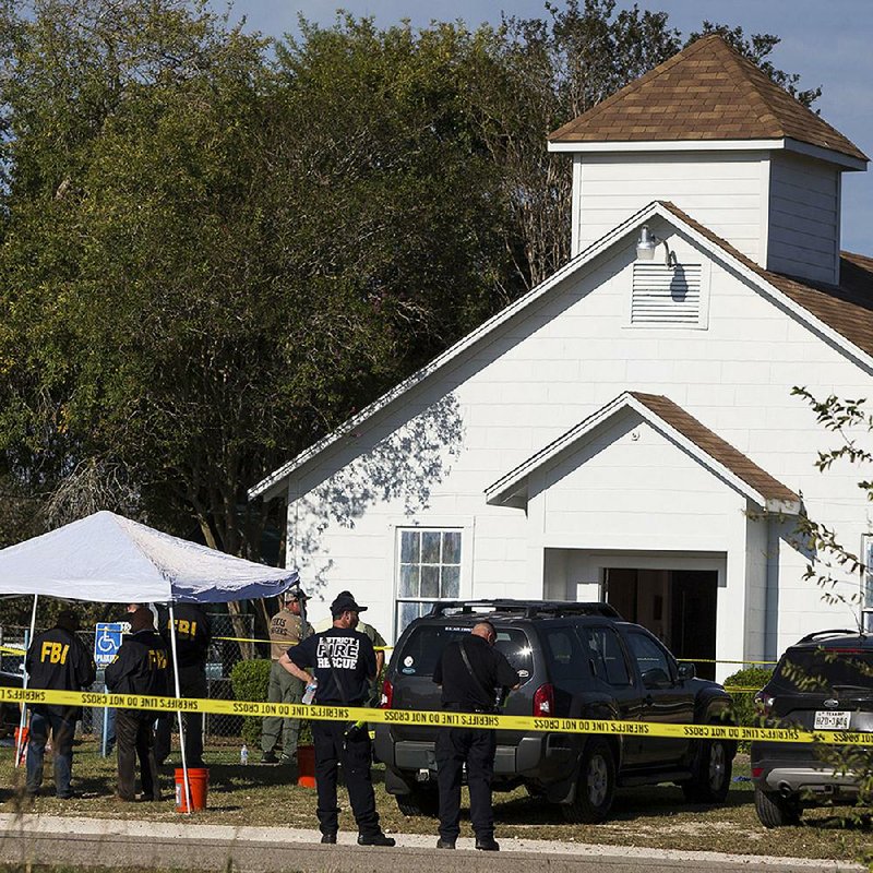 Law enforcement officials work at the scene of a fatal shooting Sunday at the First Baptist Church in Sutherland Springs, Texas.
