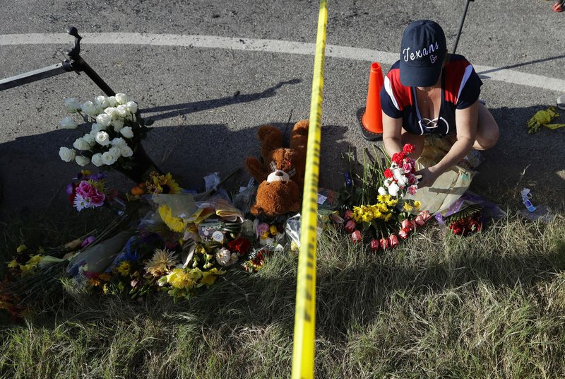 Rebecca Thompson places flowers at a makeshift memorial near the scene of a shooting at the First Baptist Church of Sutherland Springs on Monday, Nov. 6, 2017, in Sutherland Springs, Texas.