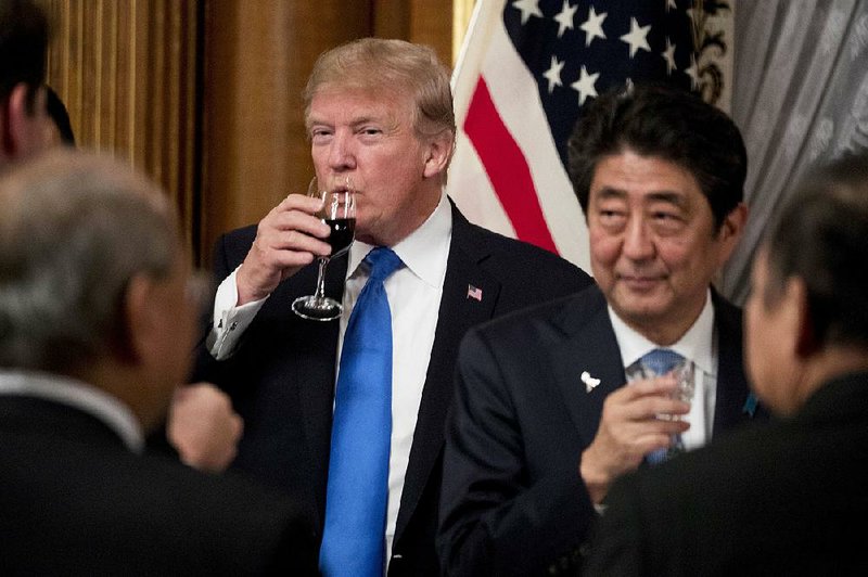U.S. President Donald Trump and Japanese Prime Minister Shinzo Abe share a drink after toasting each other during a state banquet at the Akasaka Palace on Monday in Tokyo.
