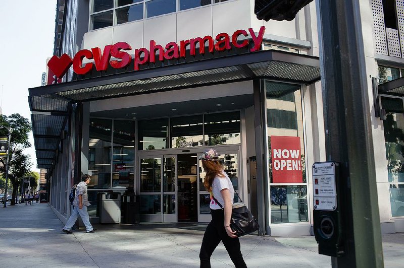 A customer nears the entrance of a CVS Health Corp. store in downtown Los Angeles in October. The pharmacy chain on Monday reported third-quarter profits of $1.29 billion, down from $1.54 billion a year ago.