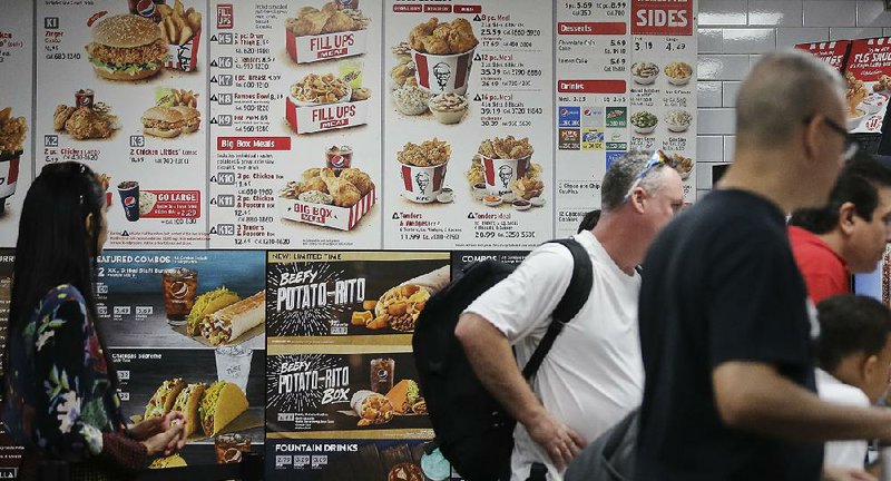 Diners check a menu recently at a KFC in New York that displays calorie counts of menu items. The Trump administration is proceeding with requirements that restaurant chains, convenience stores, pizza delivery chains and movie theaters post calorie counts of foods they serve. 