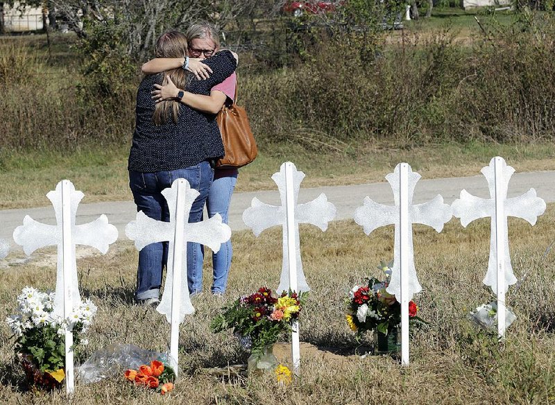 Women hug Tuesday at a memorial to the victims of the Sunday’s deadly shooting at First Baptist Church in Sutherland Springs, Texas. 