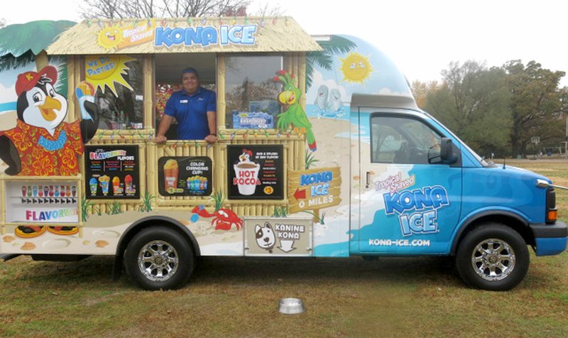 Photo by Susan Holland Antonio Ramirez, a driver for Kona Ice of Bentonville, brought his truck to the Reads for Breeds benefit Saturday, Nov. 4, at the Gravette dog park. He sold snow cones and hot chocolate in a variety of flavors with part of the profits going to the Bella Vista Animal Shelter. He also provided Kanine Kona, shaved ice for the dogs offered for adoption at the event. Books were collected for Gravette Public Library and a face painting booth was a part of the activities.