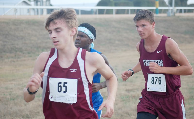 Graham Thomas/Herald-Leader Siloam Springs sophomore Adam Kennedy, right, placed 50th overall with a time of 19:43.4 on Friday at the 6A cross country meet at Oaklawn Park in Hot Springs.
